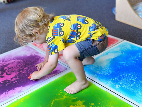 Child is painting on the paper