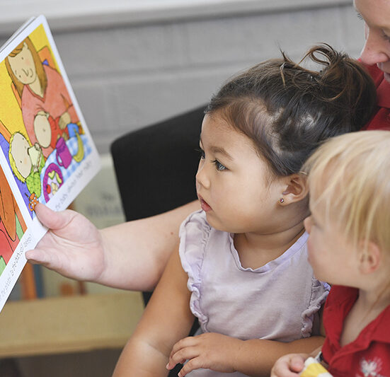 Teacher in Little Jasper Early Learning Centre teaching Kids via book